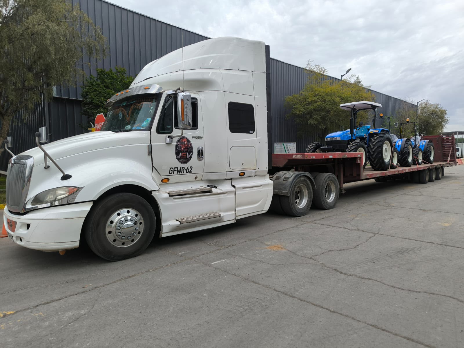 Camión de Transportes JSV con tractores azules sobre su rampla